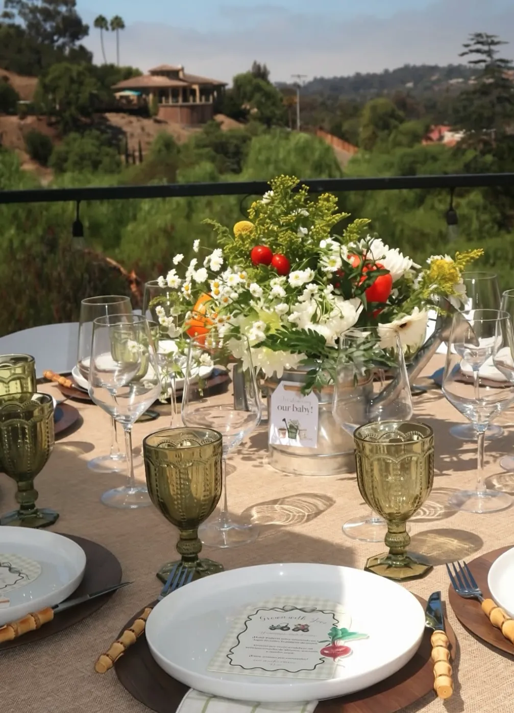 Garden table with wildflowers in a galvanized watering can overlooking the hills