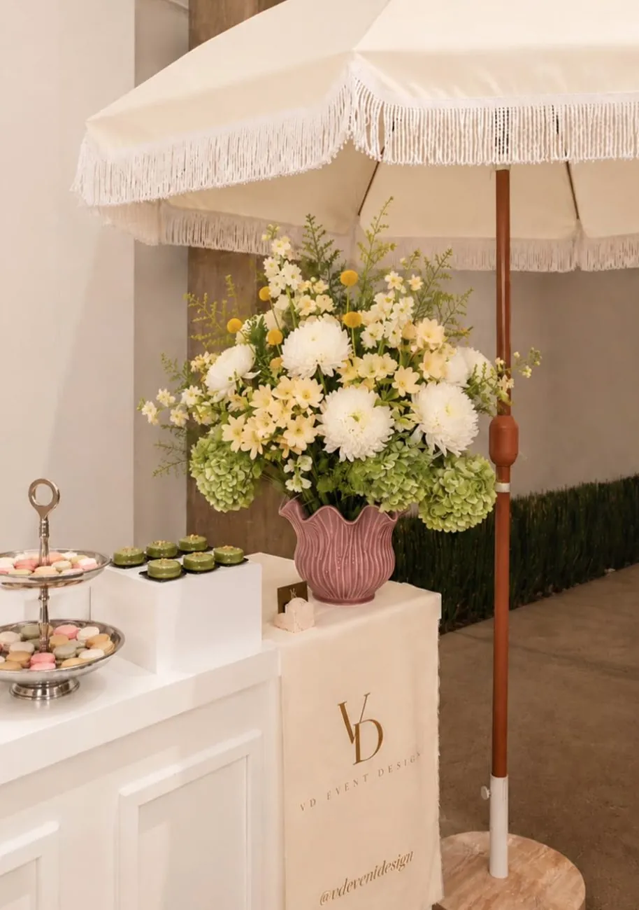 Pastry bar under a fringed white umbrella with florals